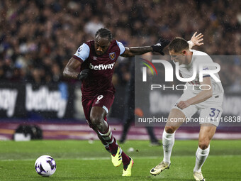 Michail Antonio of West Ham United is on the ball, being tracked by Micky Van De Ven of Tottenham Hotspur, during the Premier League match b...