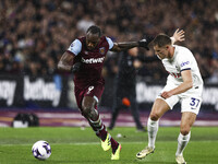 Michail Antonio of West Ham United is on the ball, being tracked by Micky Van De Ven of Tottenham Hotspur, during the Premier League match b...