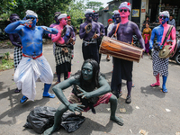 Balinese men with painted bodies are playing traditional instruments as they participate in the Ngerebeg tradition in Tegallalang Village, B...