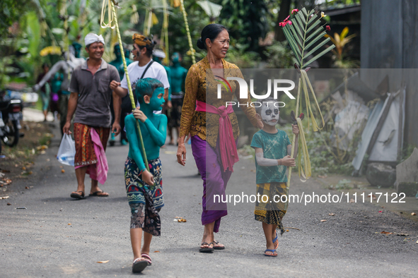 Balinese men with painted bodies are marching as they attend the Ngerebeg tradition in Tegallalang Village, Bali, Indonesia, on April 3, 202...