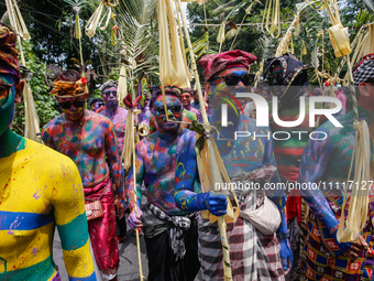 Balinese men with painted bodies are marching as they attend the Ngerebeg tradition in Tegallalang Village, Bali, Indonesia, on April 3, 202...