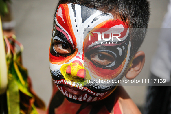 A Balinese child with a painted body is waiting while attending the Ngerebeg tradition in Tegallalang Village, Bali, Indonesia, on April 3,...