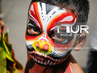 A Balinese child with a painted body is waiting while attending the Ngerebeg tradition in Tegallalang Village, Bali, Indonesia, on April 3,...