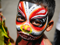 A Balinese child with a painted body is waiting while attending the Ngerebeg tradition in Tegallalang Village, Bali, Indonesia, on April 3,...