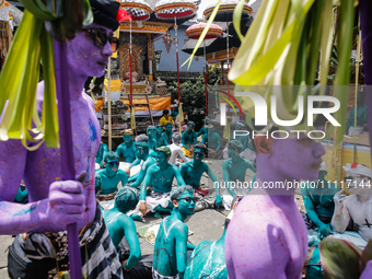 Balinese men with painted bodies are waiting as they attend the Ngerebeg tradition in Tegallalang Village, Bali, Indonesia, on April 3, 2024...