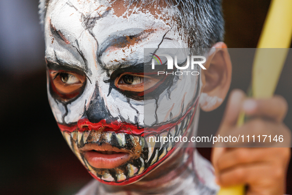 A Balinese child with a painted body is waiting while attending the Ngerebeg tradition in Tegallalang Village, Bali, Indonesia, on April 3,...