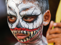 A Balinese child with a painted body is waiting while attending the Ngerebeg tradition in Tegallalang Village, Bali, Indonesia, on April 3,...