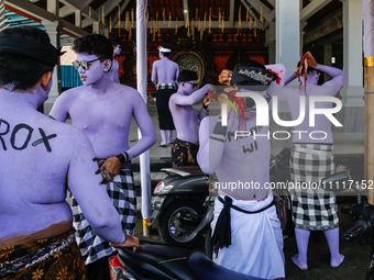 Balinese men with painted bodies are preparing to attend the Ngerebeg tradition in Tegallalang Village, Bali, Indonesia, on April 3, 2024. N...