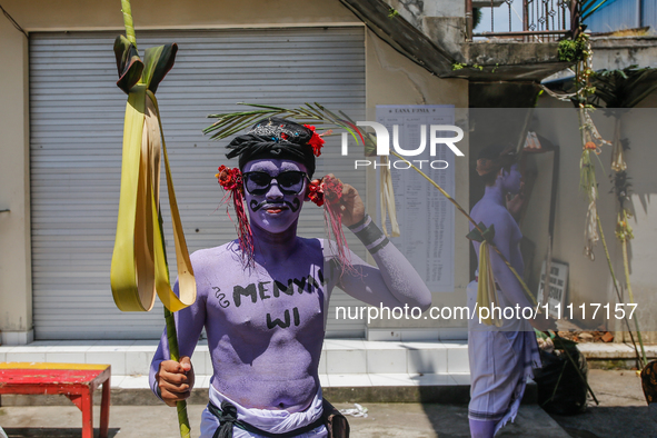 Balinese men with painted bodies are preparing to attend the Ngerebeg tradition in Tegallalang Village, Bali, Indonesia, on April 3, 2024. N...