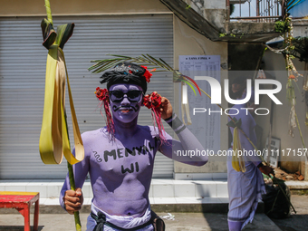 Balinese men with painted bodies are preparing to attend the Ngerebeg tradition in Tegallalang Village, Bali, Indonesia, on April 3, 2024. N...