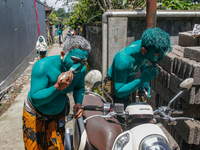 Balinese men are being painted before they attend the Ngerebeg tradition in Tegallalang Village, Bali, Indonesia, on April 3, 2024. Ngerebeg...