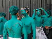 Balinese men are being painted before they attend the Ngerebeg tradition in Tegallalang Village, Bali, Indonesia, on April 3, 2024. Ngerebeg...