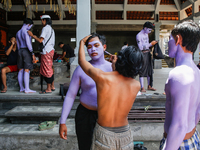 Balinese men are being painted before they attend the Ngerebeg tradition in Tegallalang Village, Bali, Indonesia, on April 3, 2024. Ngerebeg...