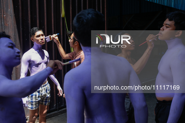 Balinese men are being painted before they attend the Ngerebeg tradition in Tegallalang Village, Bali, Indonesia, on April 3, 2024. Ngerebeg...