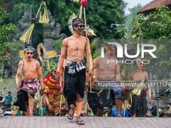 Balinese men with painted bodies are marching as they attend the Ngerebeg tradition in Tegallalang Village, Bali, Indonesia, on April 3, 202...