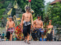 Balinese men with painted bodies are marching as they attend the Ngerebeg tradition in Tegallalang Village, Bali, Indonesia, on April 3, 202...