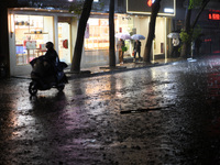 People are riding electric bikes on a street during heavy rain in Nanchang, Jiangxi Province, China, on April 2, 2024. (