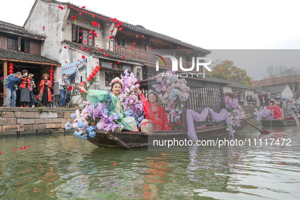 Women dressed as silkworm flowers are throwing silkworm flowers to a silkworm farmer on a boat to pray for a bumper harvest in Huzhou, China...