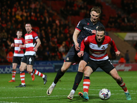 Jamie Sterry of Doncaster Rovers is holding off Sam Dalby of Wrexham during the Sky Bet League 2 match between Doncaster Rovers and Wrexham...