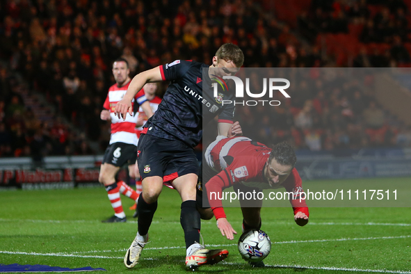 Sam Dalby of Wrexham is fouling Jamie Sterry of Doncaster Rovers during the Sky Bet League 2 match between Doncaster Rovers and Wrexham at t...