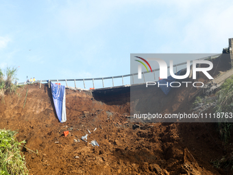 A car is plunging into a ravine after a landslide disaster on the Bogor-Ciawi-Sukabumi (Bocimi) toll road in Bogor, Indonesia, on April 4, 2...