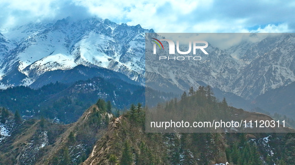 The snowy mountains are rising and falling in the Qilian Mountains National Park's horseshoe scenic area in Zhangye, China, on April 4, 2024...