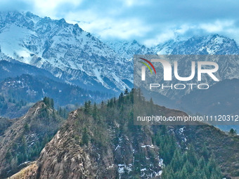 The snowy mountains are rising and falling in the Qilian Mountains National Park's horseshoe scenic area in Zhangye, China, on April 4, 2024...