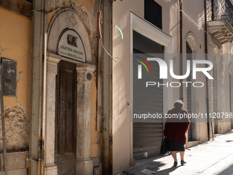 A woman walking next to damaged and rebuilt buildings is seen in L'Aquila, Italy, on April 5th, 2024. on April 6th L'Aquila will commemorate...