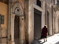 A woman walking next to damaged and rebuilt buildings is seen in L'Aquila, Italy, on April 5th, 2024. on April 6th L'Aquila will commemorate...