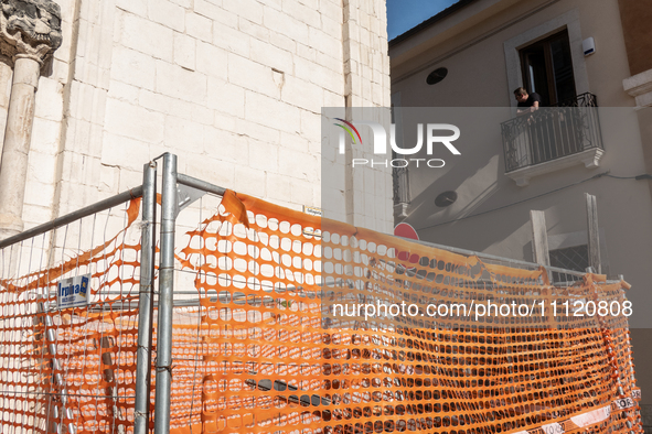 A man on his balcony and a building site are seen in L'Aquila, Italy, on April 5th, 2024. on April 6th L'Aquila will commemorate its 15th an...