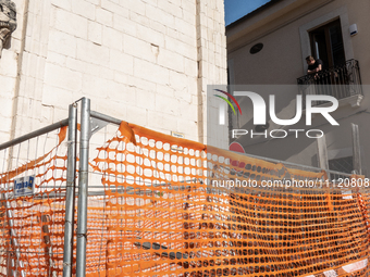 A man on his balcony and a building site are seen in L'Aquila, Italy, on April 5th, 2024. on April 6th L'Aquila will commemorate its 15th an...