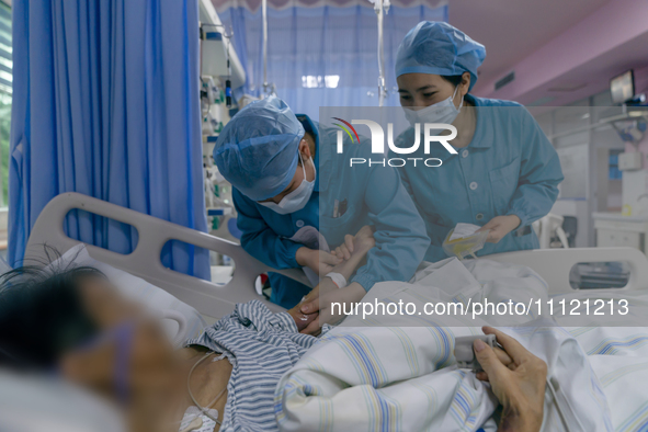 Two nurses are checking a patient before a blood transfusion in an intensive care unit in Enshi, Hubei Province, China, on April 5, 2024. 