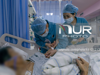 Two nurses are checking a patient before a blood transfusion in an intensive care unit in Enshi, Hubei Province, China, on April 5, 2024. (