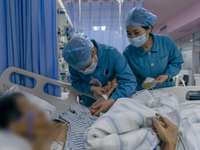 Two nurses are checking a patient before a blood transfusion in an intensive care unit in Enshi, Hubei Province, China, on April 5, 2024. (