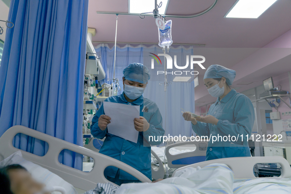 Two nurses are checking a patient before a blood transfusion in the intensive care unit in Enshi, Hubei Province, China, on April 5, 2024. 