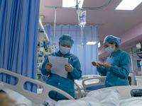 Two nurses are checking a patient before a blood transfusion in the intensive care unit in Enshi, Hubei Province, China, on April 5, 2024. (