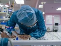 Doctors and nurses are providing medical services to seriously ill patients in an intensive care unit in Enshi, Hubei Province, China, on Ap...