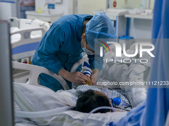 A nurse is providing intravenous infusion for a seriously ill patient in the intensive care unit in Enshi, Hubei Province, China, on April 5...