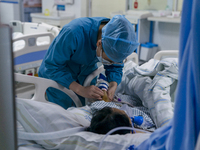 A nurse is providing intravenous infusion for a seriously ill patient in the intensive care unit in Enshi, Hubei Province, China, on April 5...