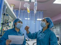 Two nurses are performing a blood transfusion for a patient in the intensive care unit in Enshi, Hubei Province, China, on April 5, 2024. (