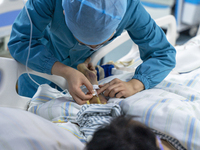 Doctors and nurses are providing medical services to seriously ill patients in an intensive care unit in Enshi, Hubei Province, China, on Ap...