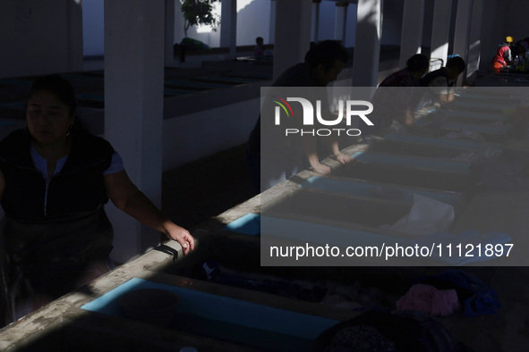 Women are washing clothes at a community laundry in Santa Cruz Acalpixca, Xochimilco, Mexico City. 