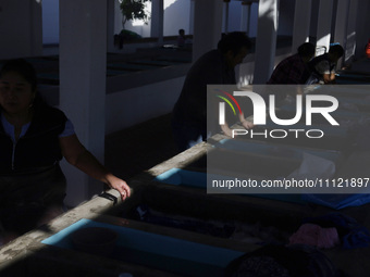 Women are washing clothes at a community laundry in Santa Cruz Acalpixca, Xochimilco, Mexico City. (