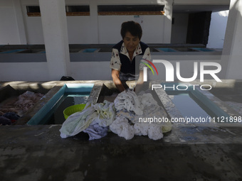 A woman is washing clothes at a community laundry in Santa Cruz Acalpixca, Xochimilco, Mexico City. (