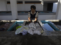 A woman is washing clothes at a community laundry in Santa Cruz Acalpixca, Xochimilco, Mexico City. (