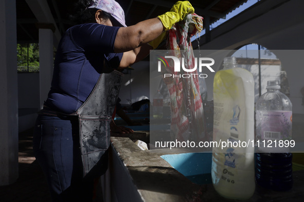 A woman is washing clothes at a community laundry in Santa Cruz Acalpixca, Xochimilco, Mexico City. 