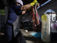 A woman is washing clothes at a community laundry in Santa Cruz Acalpixca, Xochimilco, Mexico City. (