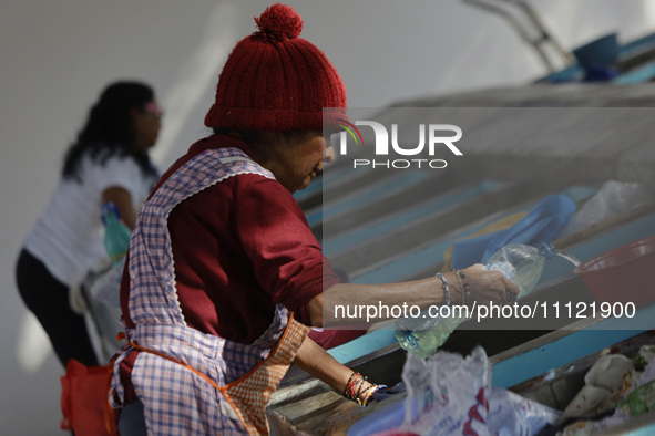 A woman is washing clothes at a community laundry in Santa Cruz Acalpixca, Xochimilco, Mexico City. 