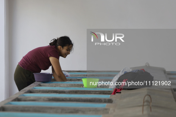 A woman is washing clothes at a community laundry in Santa Cruz Acalpixca, Xochimilco, Mexico City. 