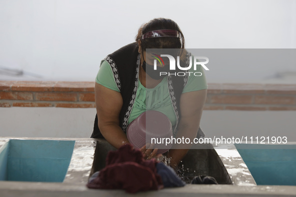 A woman is washing clothes at a community laundry in Santa Cruz Acalpixca, Xochimilco, Mexico City. 